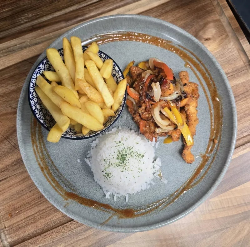 An overhead view of a plated meal with rice and chips